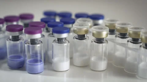 Rows of pharmaceutical glass vials with colored powder in laboratory setting. Stock Footage 337764025