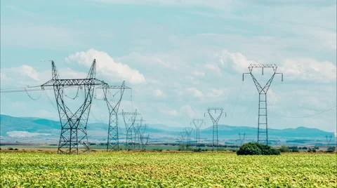Rows of power pylons in green field Video stock 53656887