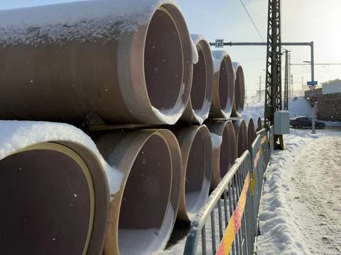 Rows of pre insulated heating pipes along snowy urban street Stock Photos