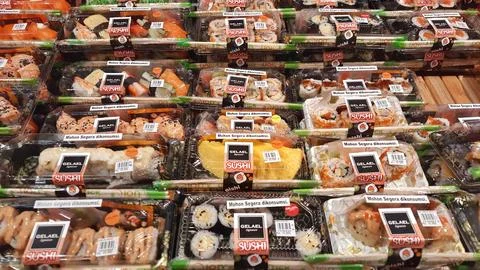 Rows of pre-packaged sushi and maki rolls on display in a gelael supermarket Stock Photos