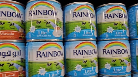Rows of Rainbow milk cans, predominantly light blue with a rainbow and green Stock Footage 311765524