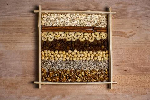 Rows of raw organic nuts and oatmeal for granola in box Stock Photos