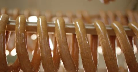 Rows of raw sausages hanging from a metal rod in warm backlight inside a Vídeo Stock 339985337