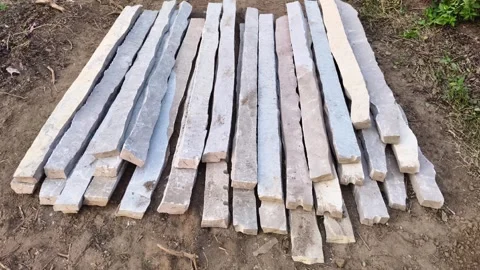 Rows of rectangular natural stone pillars laid on ground Stockbeeldmateriaal 325416303