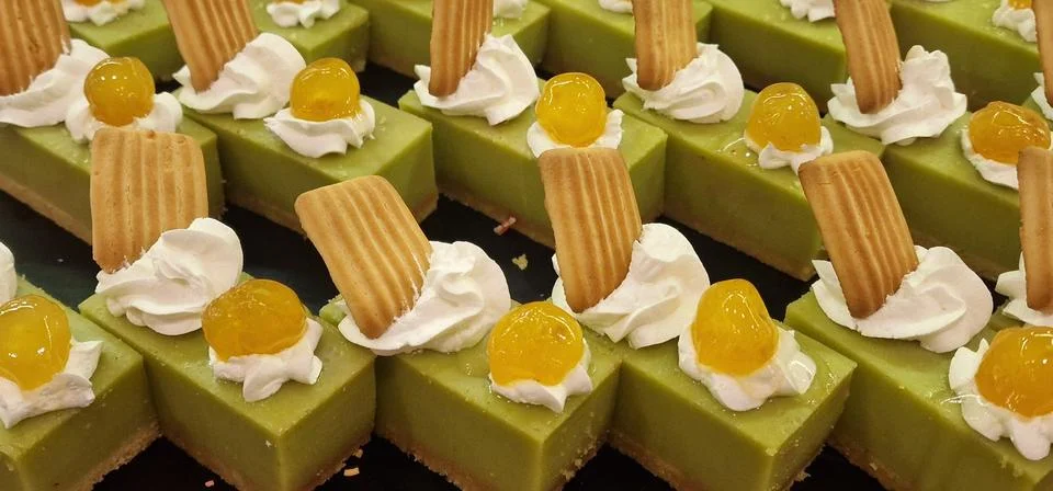 Rows of rectangular pistachio cakes on a crisp biscuit base, each piece metic Stock Photos