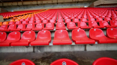 Rows of red and orange plastic seats at low price zone Stock Footage