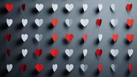 Rows of red and white paper hearts hanging on strings, creating a romantic 库存影片 347876098