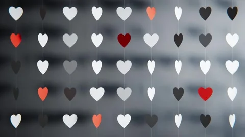 Rows of red and white paper hearts hanging on strings, creating a romantic 库存影片 347876214