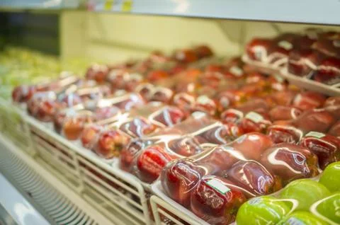 Rows of red apples in plastic package on shelf in store Stock Photos