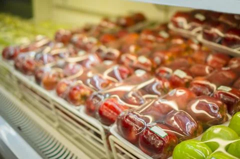 Rows of red apples in plastic package on shelf in store Stock Photos