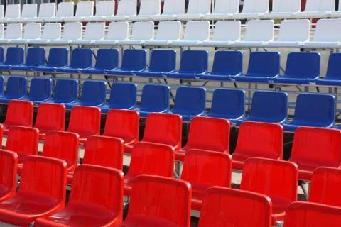 Rows of red, blue and white plastic chairs Stock Photos