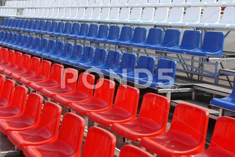 Rows of red, blue and white plastic chairs Stock Photos