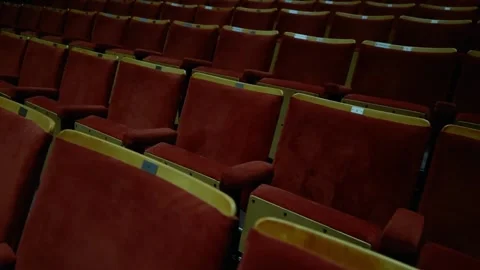 Rows of Red Chairs in the Darkened Auditorium of the Theater Video stock 258152038