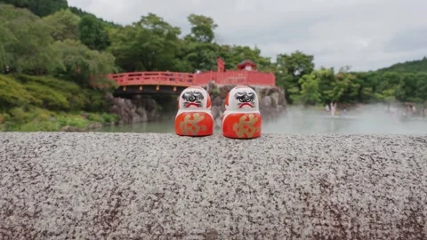 Rows of red Daruma dolls rest on stone platform at Katsuoji Temple in Osaka Stock Footage 344281504