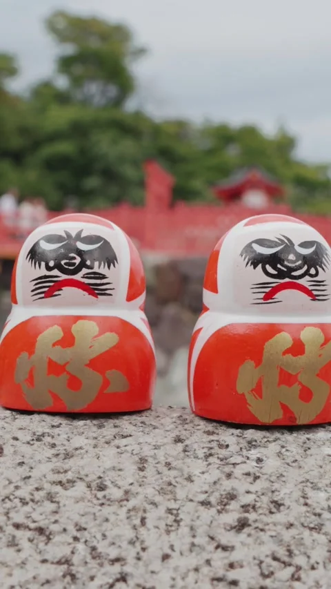 Rows of red Daruma dolls rest on stone platform at Katsuoji Temple in Osaka Stock Footage 345740518