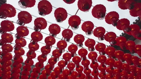 Rows of Red Lanterns Hanging Outdoors Across Urban Rooftops on a Cloudy Day Stock Footage 336770621