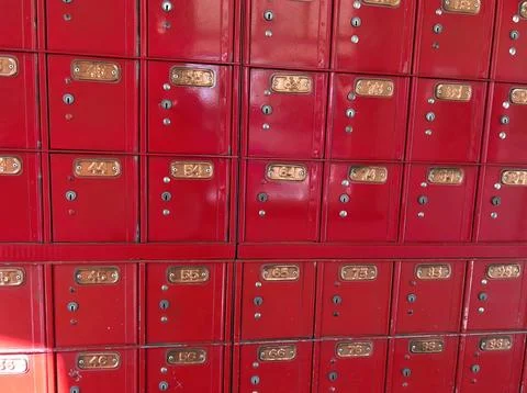 Rows of red metal post office boxes on a wall in the post office Stock Photos
