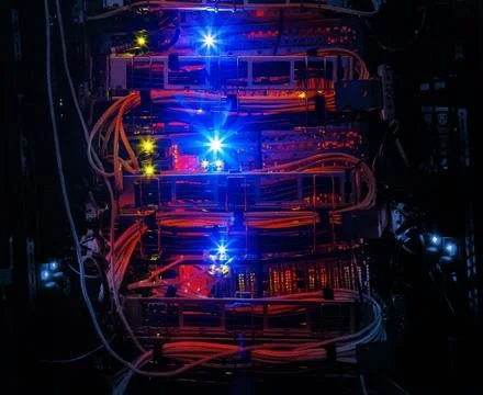 Rows of red network cables connected to router and switch hub in server room at Stock Photos