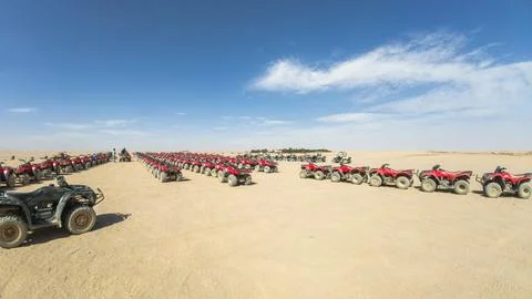Rows of Red Quad Bikes Parked in Desert Before ATV Safari Adventure Stock Photos