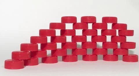 Rows of the red ribbed plastic bottle caps laying on each other. the throug.. Stock Photos