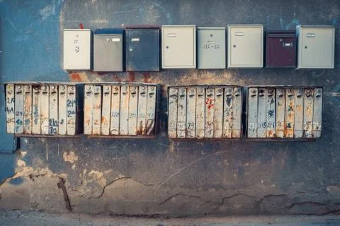 Rows of retro rusty and modern mailboxes on old wall. Stock Photos