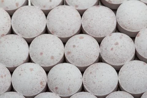 Rows of round, speckled tablets fill the frame Stock Photos