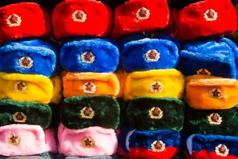 Rows of russian winter hats of different colors with army emblems at the stre Stock-Fotos