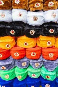 Rows of russian winter hats of different colors with army emblems at the street Stock Photos