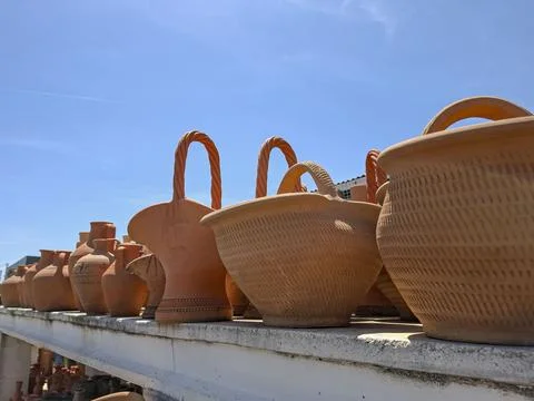 Rows of rustic terracotta baskets under a blue sky show artisanal pottery a.. Stock-Fotos