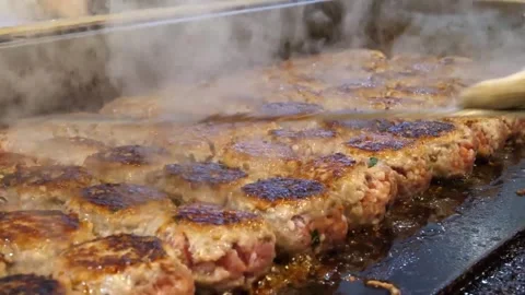 Rows of Savory Meat Patties Sizzling on a Commercial Flat Top Grill Video stock 343587326