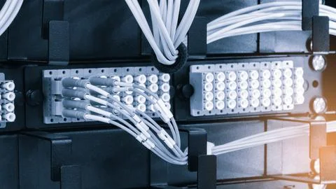 Rows of server racks dominate the scene. Numerous ports connect to coiled whi Stock-Fotos