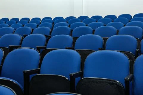 Rows of several blue chairs in an auditorium, or theater Stock Photos