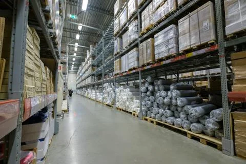 Rows of shelves and pallets with boxes and products on it in modern self se.. Foto stock