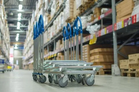Rows of shelves with boxes and storage carts in modern warehouse Stock Photos