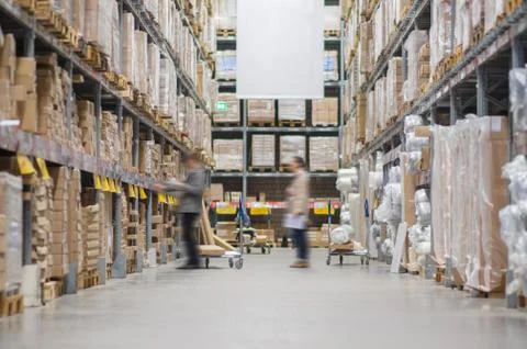 Rows of shelves with boxes in modern warehouse with customers walking Stock Photos