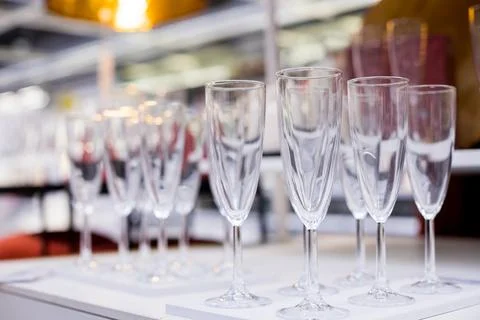 Rows of shiny empty high glasses with reflections in restaurant. Catering Foto stock