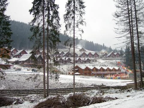 Rows of ski resort hotels in front of mountains covered with trees Stock Photos