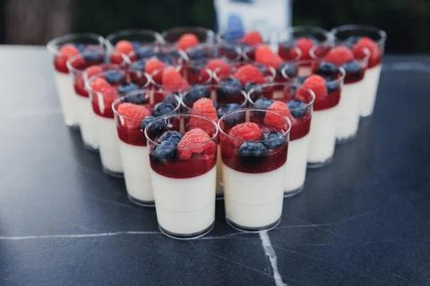 Rows of small glass cups hold creamy dessert Foto stock