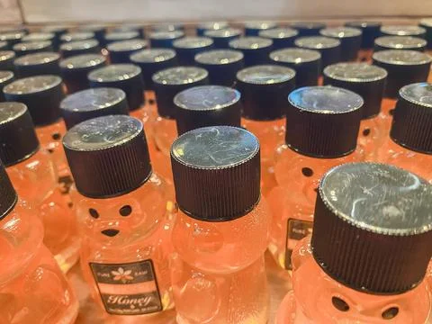 Rows of small plastic honey bear bottles with black caps on a shelf - Augus.. Fotos Stock