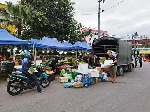 Rows of small roadside stalls with blue canvas roofs selling culinary goods Stock-Fotos