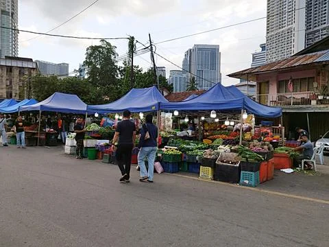 Rows of small roadside stalls with blue canvas roofs selling culinary goods Stock Photos
