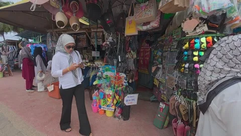 Rows of small shops at Pantai Teluk Kemang offer souvenirs and beach essentials. Stock Footage 308456257