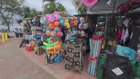 Rows of small shops at Pantai Teluk Kemang offer souvenirs and beach essentials. Stock Footage 308456307