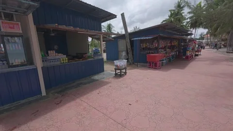 Rows of small shops at Pantai Teluk Kemang offer souvenirs and beach essentials. Stock Footage 308456362