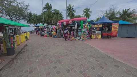 Rows of small shops at Pantai Teluk Kemang offer souvenirs and beach essentials. Stock Footage 308456441