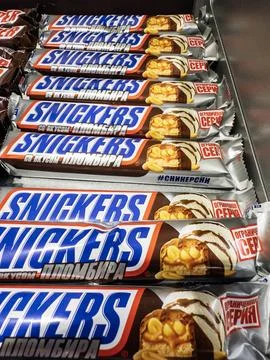 Rows of Snickers candy bars displayed in a retail setting capturing sweet i.. Photos