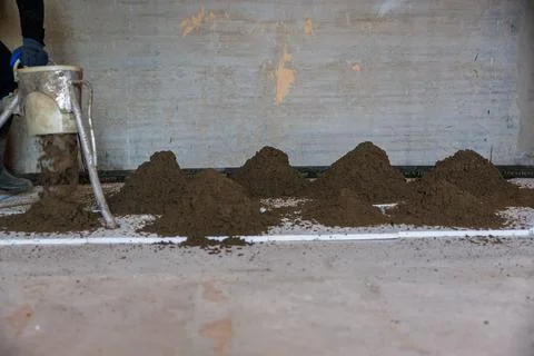 Rows of Soil Piles on Flat Surface in Indoor Construction Setting Stock Photos