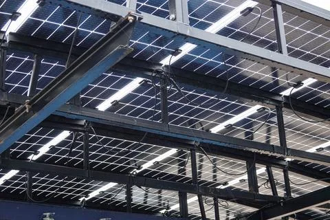 Rows of solar panels are mounted on a sturdy metal framework, harnessing su.. Stock Photos