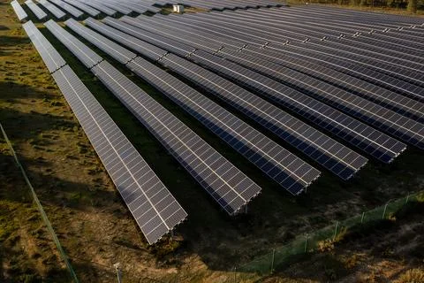 Rows of solar panels in countryside fields on sunny day Stock Photos
