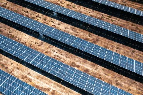 Rows of solar panels in countryside fields on sunny day Stock Photos